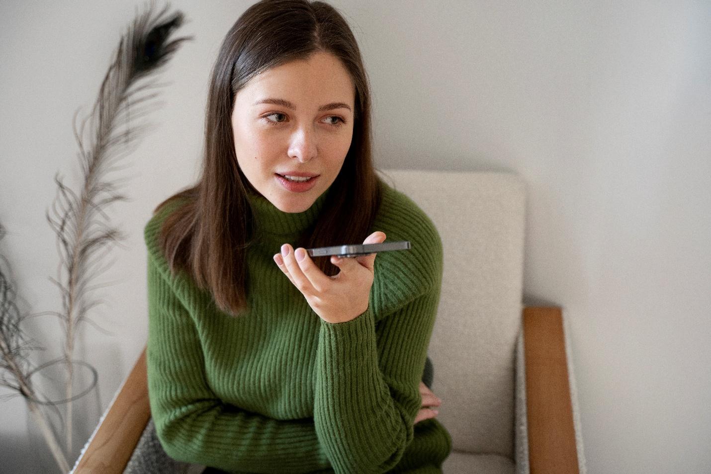 Persoana care &icirc;ntreaba un asistent AI conversational o &icirc;ntrebare de pe smartphone
